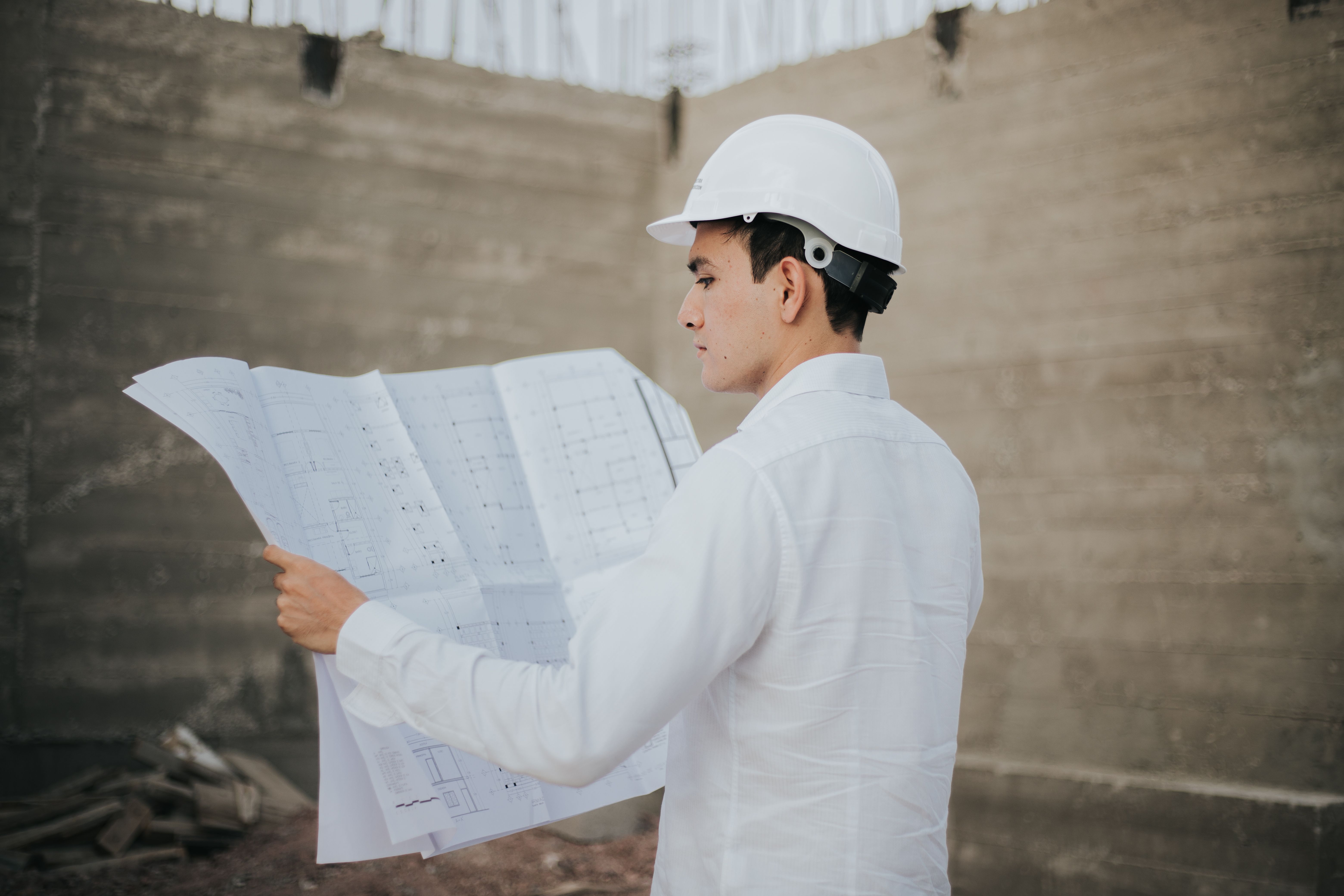 Profesional de la construcción revisando planos en una obra